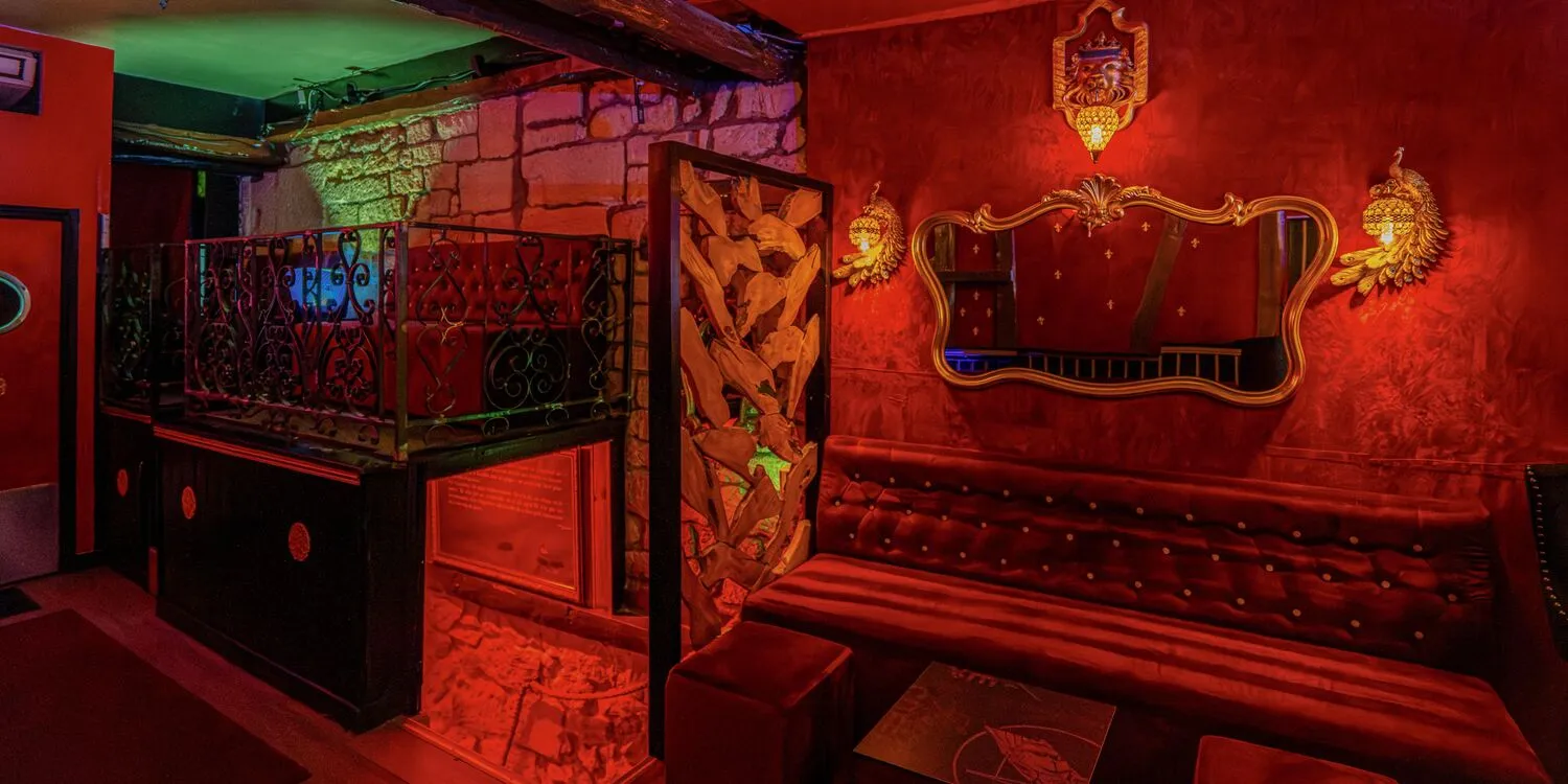 Un salon avec banquettes et miroir au rez-de-chaussée